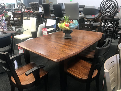 Amish brown rectangular table wiht black back and wood chairs 